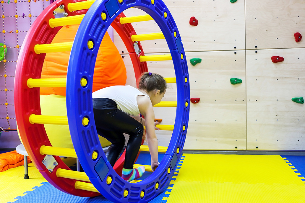 an autistic girl passes in a squirrel wheel with a ladder treatment in at the doctor, runs in the device at speed